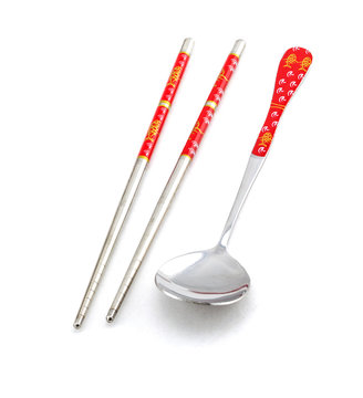 chopsticks and tablespoon on white background