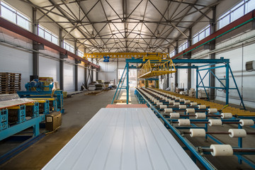 Thermal insulation sandwich panel production line. Machine tools, roller conveyor and overhead crane in workshop
