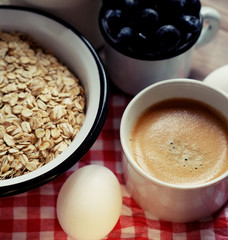 A healthy breakfast is a great start to a new day. Oatmeal porridge, coffee, berries and nuts on a wooden table.