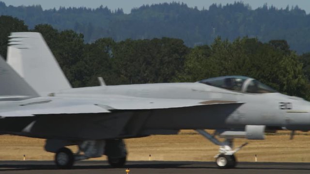 F-18 jet taxiing through frame with heat waves
