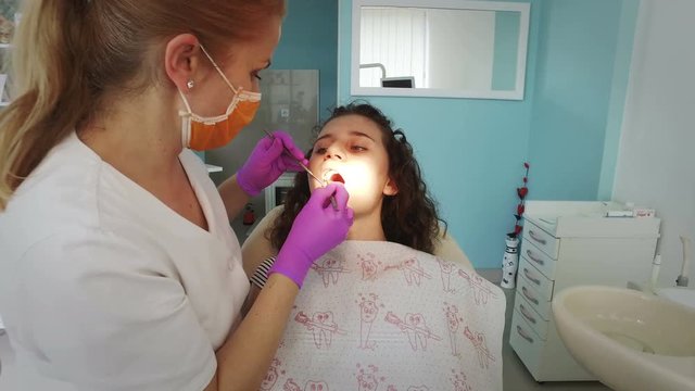 Dentist Examining A Young Patient With Tools