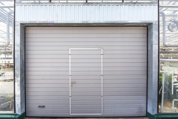 Shutter door or roller door in greenhouse building facade