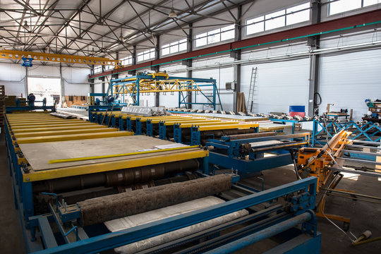 Thermal insulation sandwich panel production line for construction. Manufacturing storage with machine tools, roller conveyor