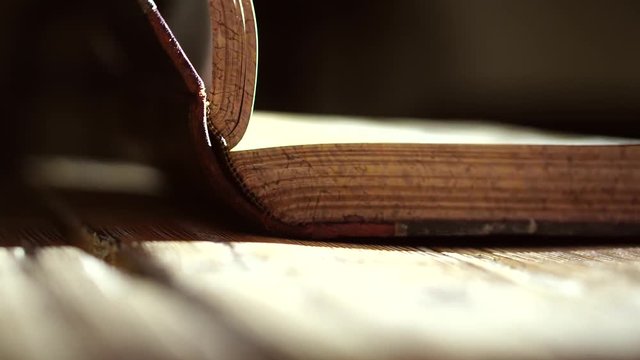 Man is pointing to specific searched explanation on page, of an old book. Close-up horizontal slider shot