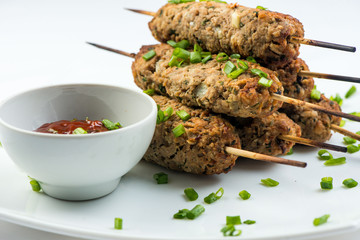 kebab with herbs on a white plate on a white background