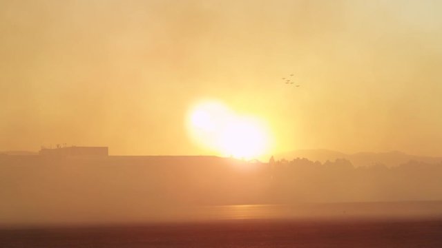 Backlit tawny smoke on airport runway 