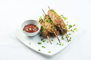 kebab with herbs on a white plate on a white background