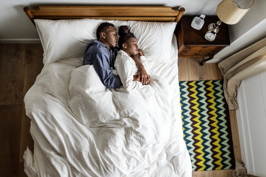 Lovely African American couple snuggling in bed