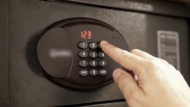 The man opens the code safe and gets out his valuable papers and documents  Safe in the hotel closet. cinematic dof
