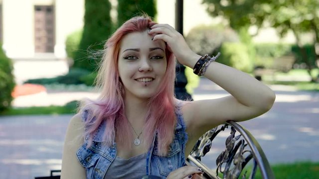 Attractive young teenage girl with pink hair looking at camera. Slow motion. HD
