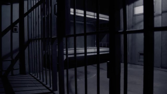 EMPTY JAIL CELL AT NIGHT, LOW ANGLE SLIDER SHOT