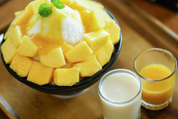 Korean shaved milk ice topped by fresh mango. Mango bingsu.