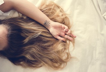 Woman with brunette hair lying down on the bed