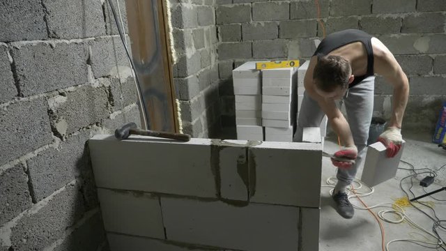 a construction site, a builder puts a wall of gas blocks. 4k.