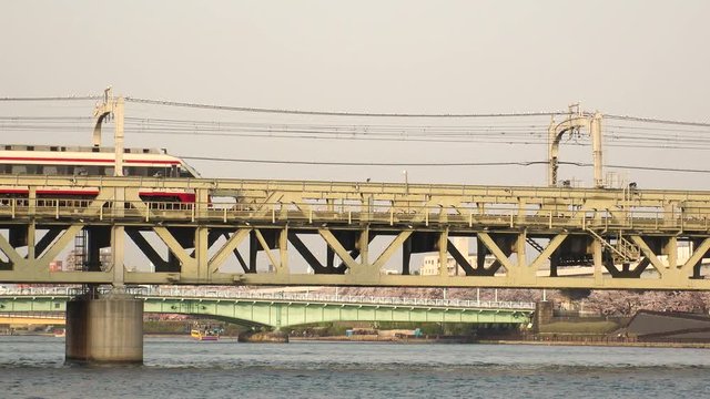 ASAKUSA, TOKYO,  JAPAN - CIRCA APRIL 2018 : Scenery of TRAIN crossing the bridge at sumida river in sunset.