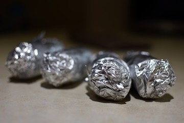 Vegetables wrapped in aluminium foil background