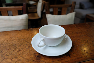 Coffee cup in coffee on table in cafe