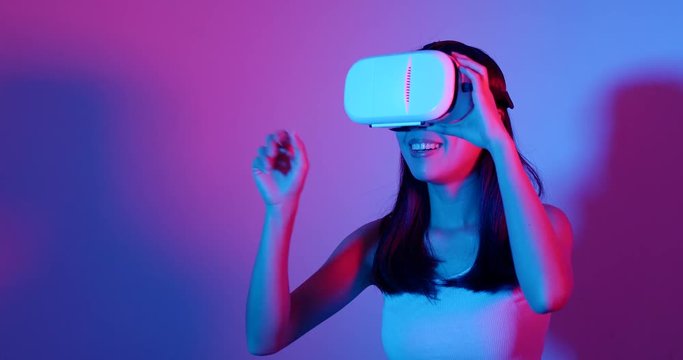 Woman watching with VR headset with cyber lighting