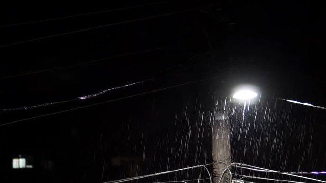 Heavy rain at night with electric post light. Realistic rain drops with thunder light strikes, background LOOP, sound included