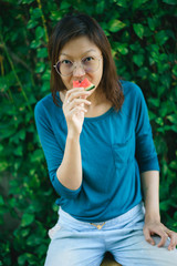 Fototapeta premium Asian Women biting Slice Of Watermelon