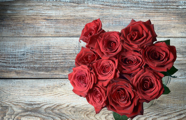 red roses bouquet on old painted boards background for valentine mother's day birthday