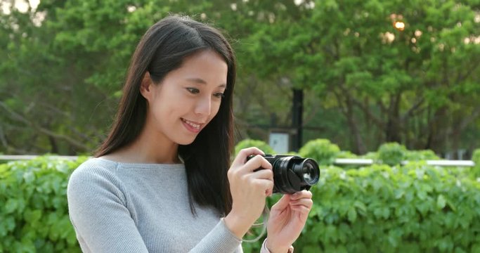 Young Woman taking photo on camera in the park