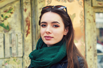 Fototapeta premium close-up portrait of a young beautiful fashionable girl posing on the street. Women's fashion concept.