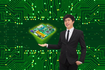 Businessman presenting a computer mother board with the background of the green eletronic circuit board.