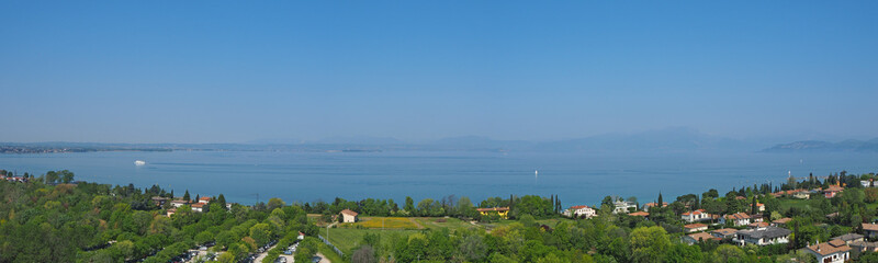 Fototapeta na wymiar Aerial landscape of Lake Garda and its hills (blue water and green meadows contrast)