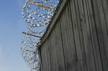 high fence with barbed wire on a blue sky