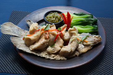 Tasty fried fish with vegetables and sauce