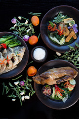 Many various dishes top view. Fish, duck, chiken on dark background