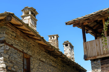 Fototapeta na wymiar Old authentic rustic houses made of stone bricks and stone slate roofs in Kovachevitsa, Bulgaria against cloudless sky in sunny day
