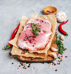 Fresh raw pork chops with spices and herbs