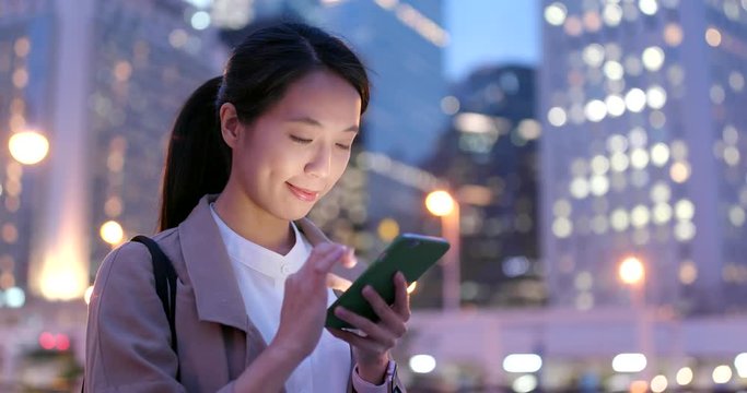 Business woman work on mobile phone at night