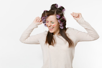 Fun young woman with curlers on hair standing isolated on white background. Crazy makeup with set...