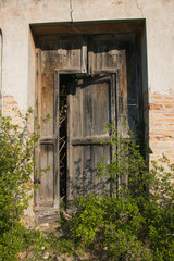Fototapeta na wymiar Antica porta in legno di una chiesa diroccata