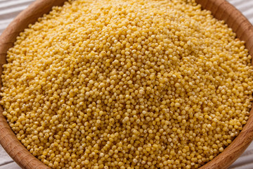 bowl of millet on a white wooden background