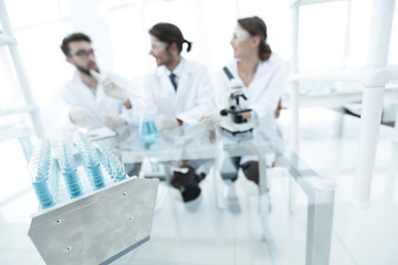 background image of scientists studying blue liquid in a flask