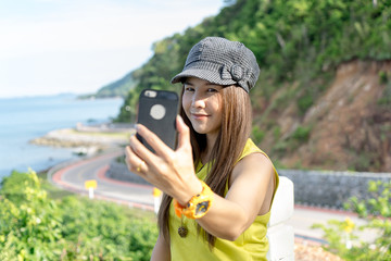 Young Asian woman taking selfie with nature view.