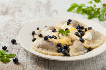 Delicious dumplings with fresh blueberries served with whipped cream and sugar or sauce.