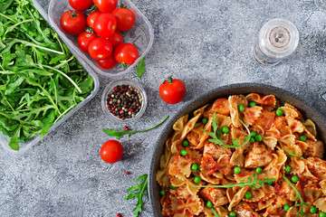 Farfalle pasta with chicken fillet, tomato sauce and green peas. Homemade food. Italian Cuisine. Flat lay.Food menu. Top view