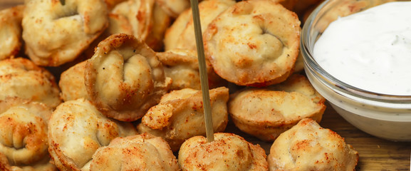 Dumplings stuffed with meat sprinkled with fresh herbs , top view, black background