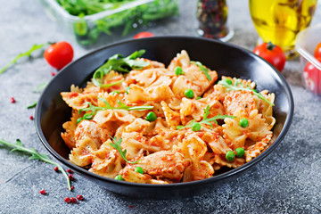 Farfalle pasta with chicken fillet, tomato sauce and green peas. Homemade food. Italian meal. Food menu