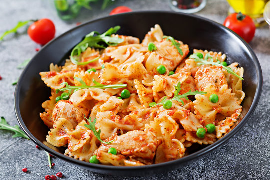 Farfalle pasta with chicken fillet, tomato sauce and green peas.  Italian meal. Food menu