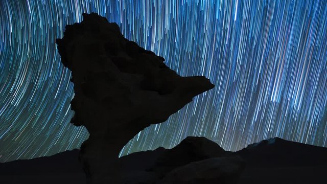 Timelapse of the night sky with stars like comets and rock formation named Arbol de Piedra (Stone Tree), Bolivia