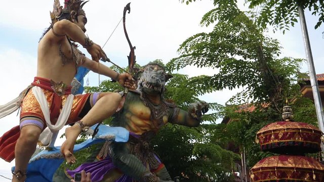 slow motion shot of two rotating ogoh-ogoh statues on a kuta street in bali during new year festivities