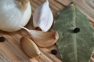 onion, garlic, black pepper and bay leaf on a wooden background