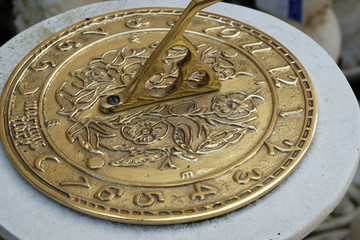 Brass sun dial on concrete base.