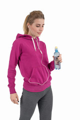 Lifestyle of the young attractive woman. She stands in a sports suit with a water small bottle